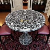 Mesa de comedor con diseño floral e incrustaciones de nácar en color negro
