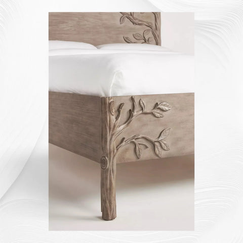 Close-up of carved branch details on brown wood bed footboard